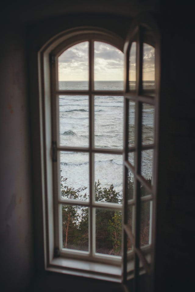 an-old-window-overlooking-the-ocean an old window overlooking the ocean